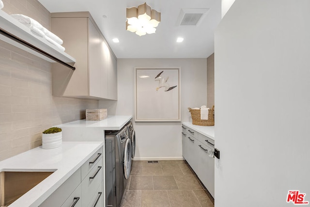 interior space with decorative backsplash, washer and dryer, and white cabinetry