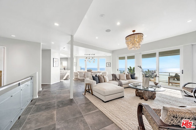 living room with an inviting chandelier and a water view