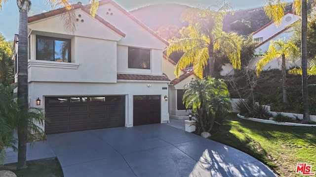 mediterranean / spanish house featuring a front yard and a garage