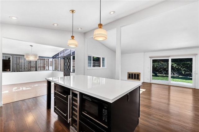 kitchen with decorative light fixtures, dark wood-type flooring, lofted ceiling, and a kitchen island