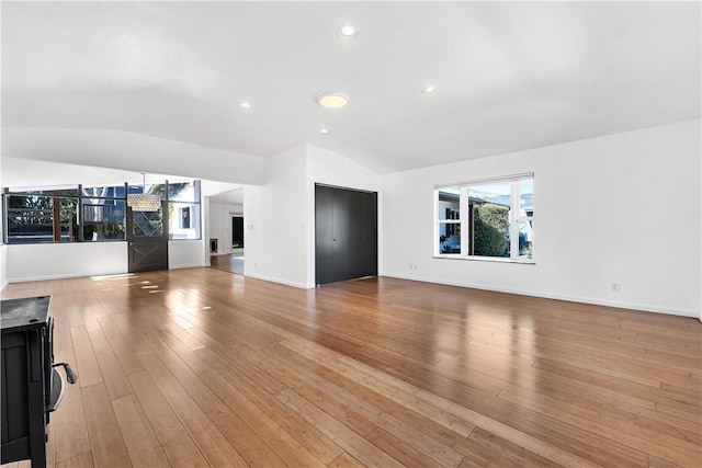 unfurnished living room with light hardwood / wood-style flooring and vaulted ceiling