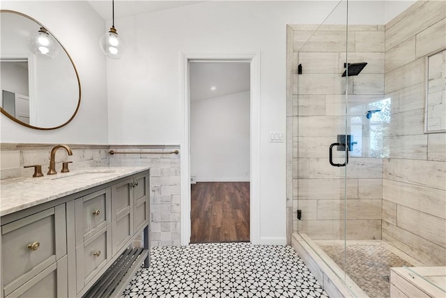 bathroom with a shower with shower door and vanity