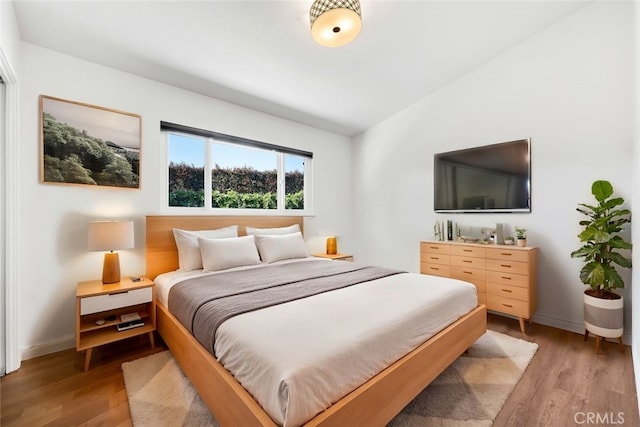 bedroom with wood-type flooring and lofted ceiling