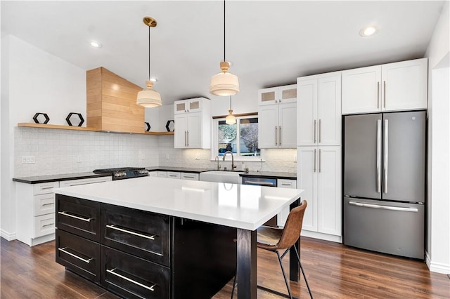 kitchen featuring a center island, white cabinets, sink, dark hardwood / wood-style floors, and stainless steel fridge