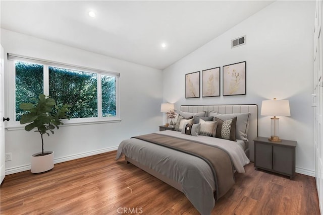 bedroom featuring hardwood / wood-style flooring and lofted ceiling