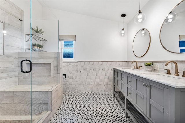 bathroom featuring a shower with shower door, vanity, and tile walls