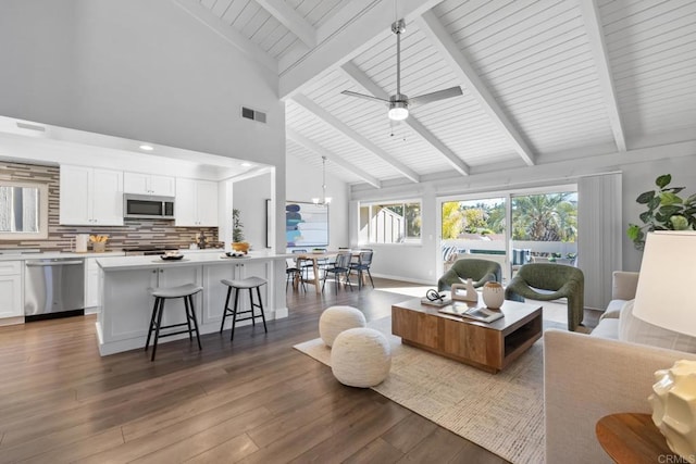 living room with high vaulted ceiling, dark wood-type flooring, beam ceiling, and ceiling fan with notable chandelier