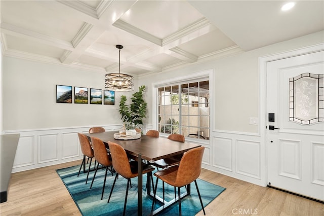 dining space featuring a notable chandelier, beamed ceiling, coffered ceiling, and light hardwood / wood-style flooring