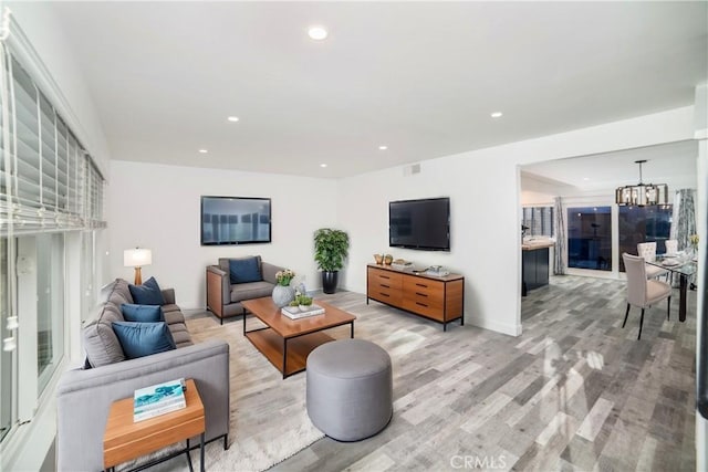 living room featuring a notable chandelier and light hardwood / wood-style flooring