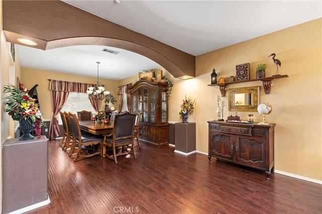 dining room with dark hardwood / wood-style flooring and a chandelier