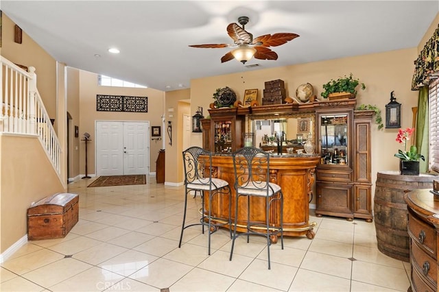 bar featuring ceiling fan, vaulted ceiling, and light tile patterned floors