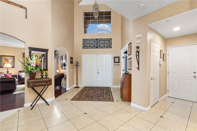 tiled entryway with a towering ceiling