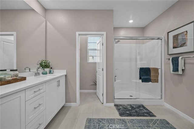 bathroom featuring a shower with shower door, vanity, and tile patterned floors