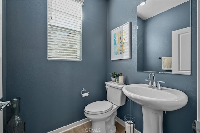 bathroom featuring hardwood / wood-style flooring and toilet