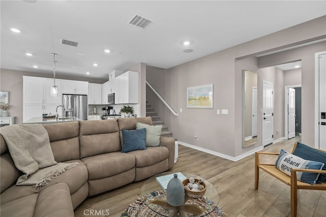 living room featuring light hardwood / wood-style flooring and sink