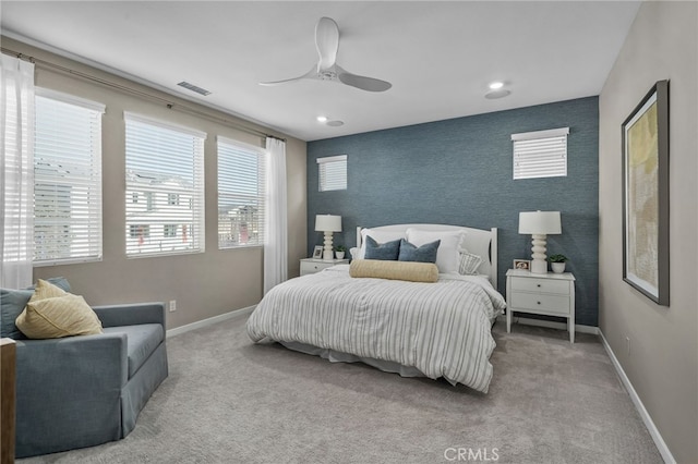 carpeted bedroom featuring ceiling fan and multiple windows