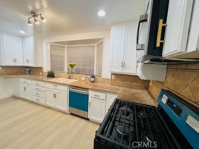 kitchen with white cabinetry, stainless steel dishwasher, and gas range oven