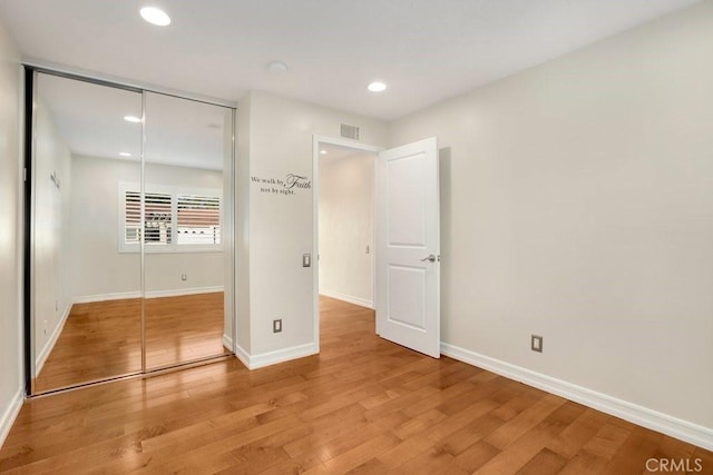 unfurnished bedroom with a closet and hardwood / wood-style floors