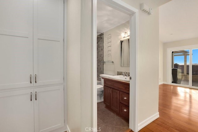 bathroom with toilet, hardwood / wood-style flooring, and vanity