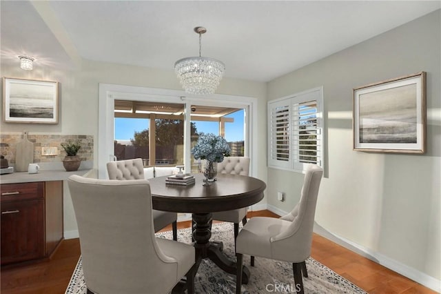 dining area with dark hardwood / wood-style flooring and an inviting chandelier