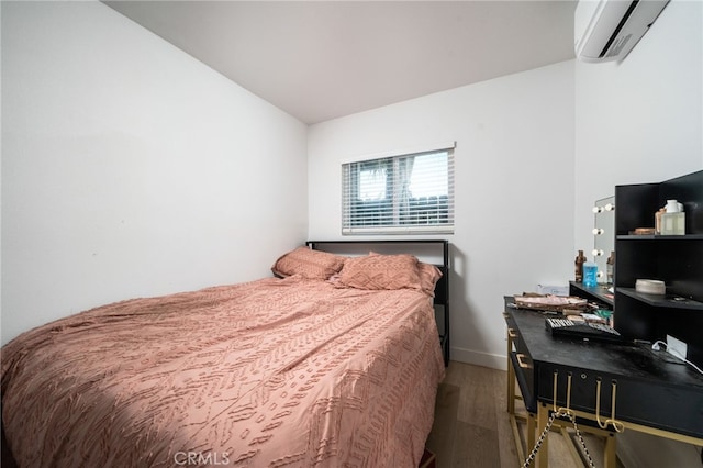 bedroom featuring wood-type flooring and an AC wall unit