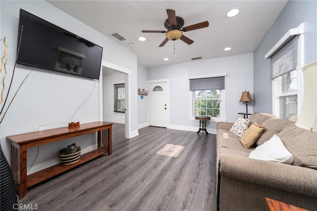 living room with ceiling fan and dark wood-type flooring