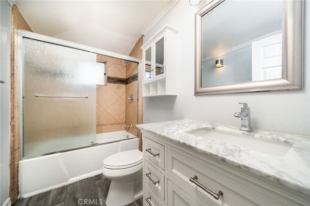 full bathroom with toilet, hardwood / wood-style flooring, crown molding, vanity, and shower / bath combination with glass door