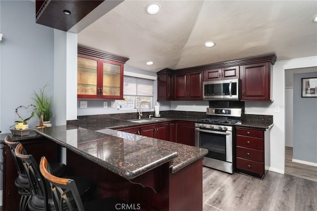 kitchen featuring sink, appliances with stainless steel finishes, kitchen peninsula, and a breakfast bar area