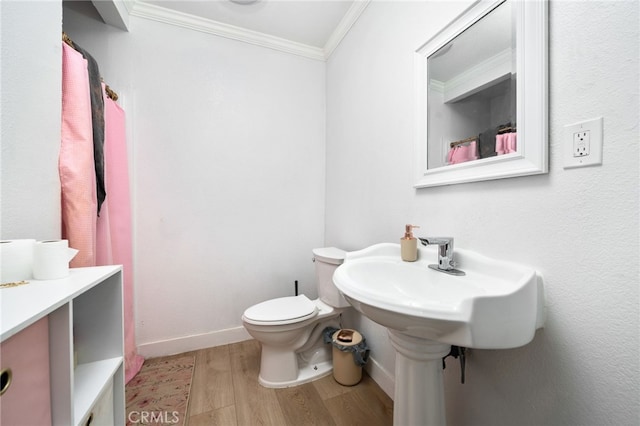 bathroom with toilet, crown molding, and hardwood / wood-style floors