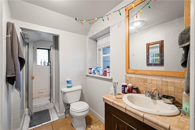 bathroom with toilet, vanity, tile patterned flooring, decorative backsplash, and an enclosed shower