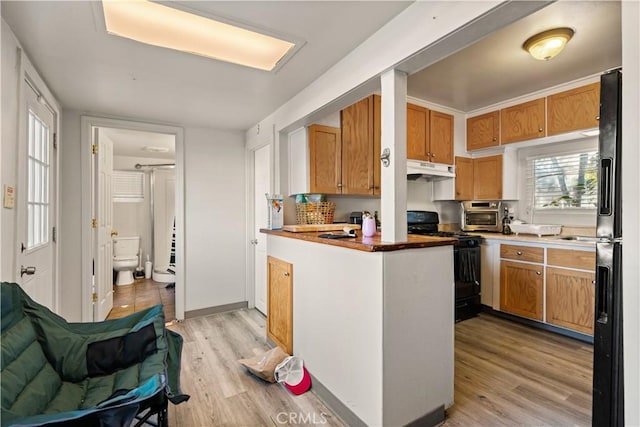 kitchen featuring black appliances and light hardwood / wood-style floors