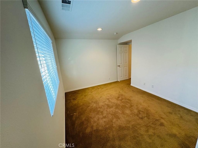 spare room featuring lofted ceiling and carpet