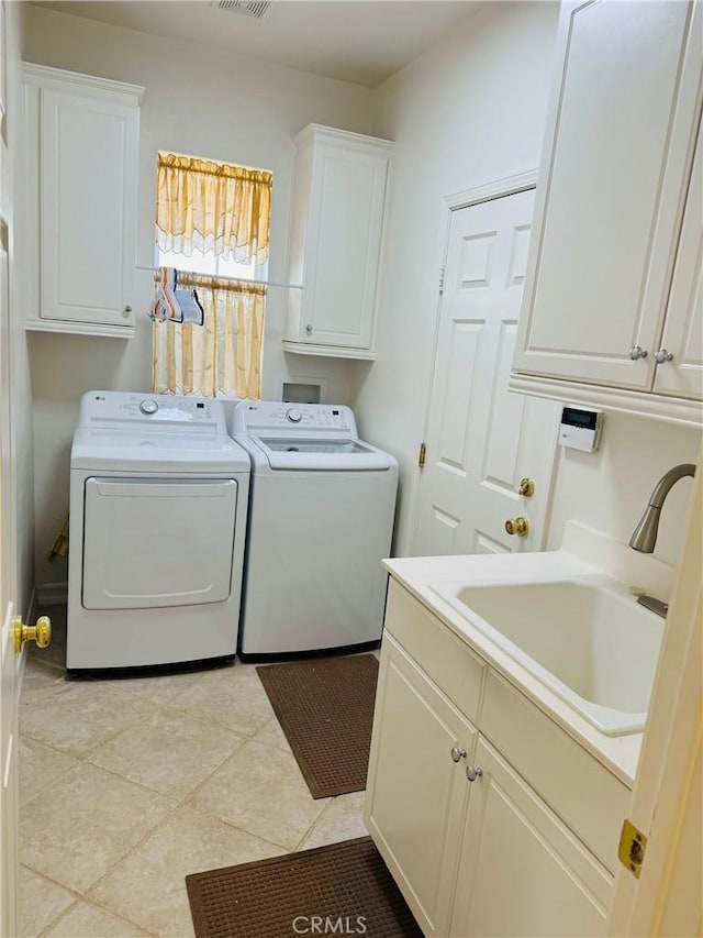 clothes washing area with cabinets, sink, washer and dryer, and light tile patterned flooring