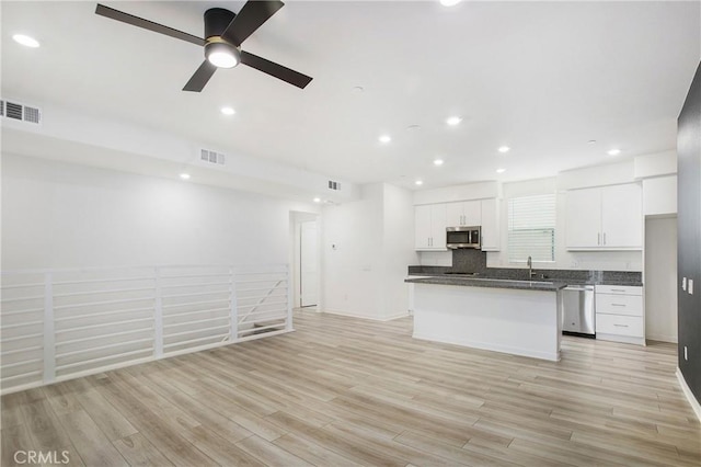 kitchen with appliances with stainless steel finishes, a center island, light hardwood / wood-style flooring, and white cabinets