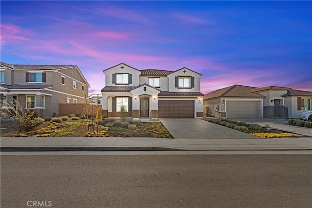 view of front of house featuring an attached garage, fence, a tile roof, concrete driveway, and stucco siding