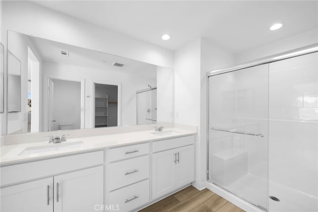 bathroom with hardwood / wood-style flooring, toilet, a shower with shower door, and vanity