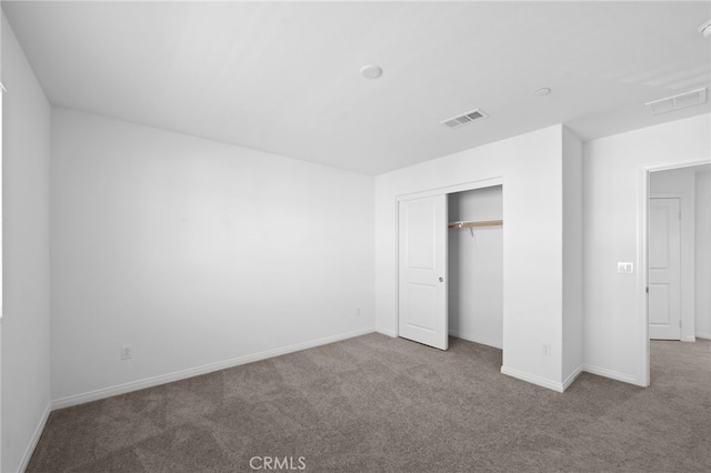 unfurnished bedroom featuring a closet and light carpet