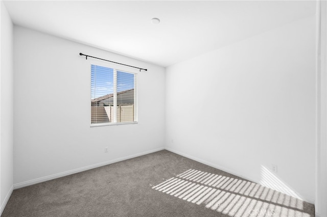 spare room with carpet and baseboards