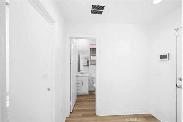 hallway with light hardwood / wood-style floors