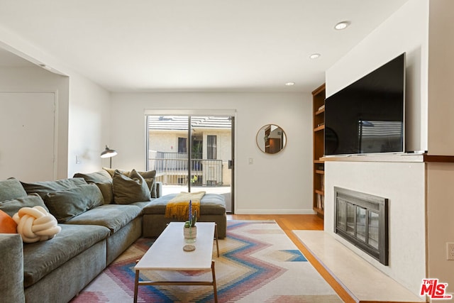 living room featuring built in features and light hardwood / wood-style floors