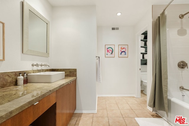 full bathroom featuring toilet, vanity, tile patterned floors, and shower / bath combination with curtain