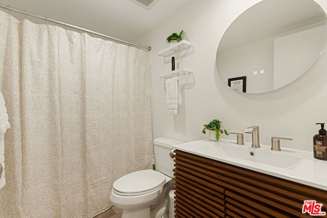 bathroom featuring toilet and vanity