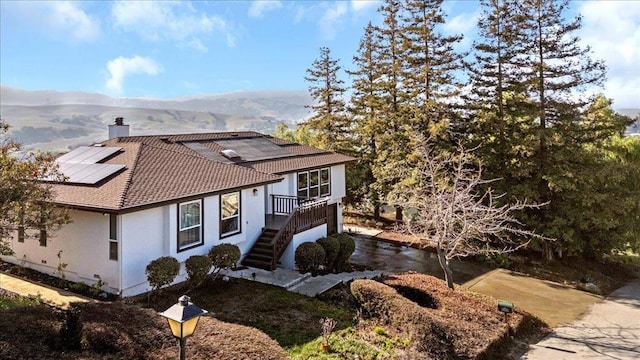 view of home's exterior with a mountain view and solar panels