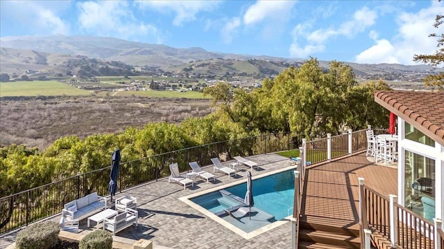 view of swimming pool with a mountain view and a patio