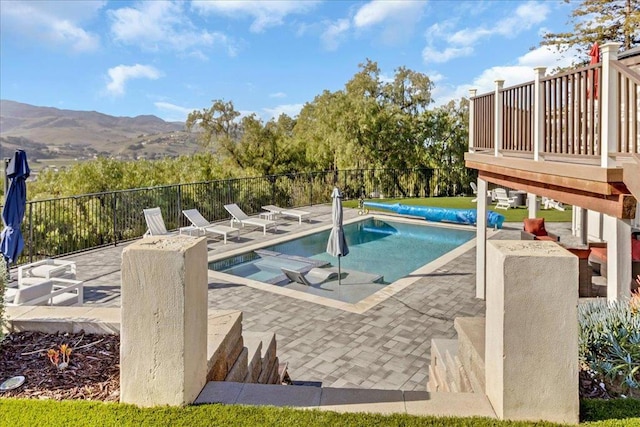 view of swimming pool with a mountain view and a patio area