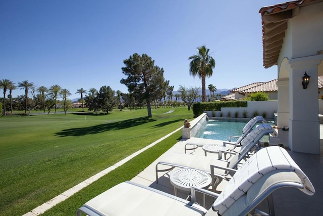 view of pool with pool water feature, a patio area, and a yard