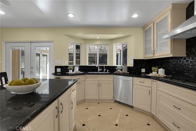 kitchen featuring stainless steel dishwasher, sink, light tile patterned flooring, french doors, and wall chimney exhaust hood