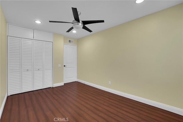 unfurnished bedroom featuring dark wood-type flooring, ceiling fan, and a closet