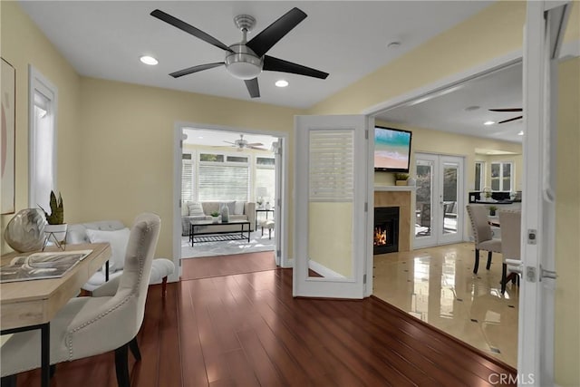 interior space with french doors, a tiled fireplace, and hardwood / wood-style floors