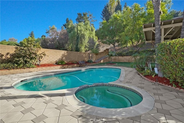 view of swimming pool featuring an in ground hot tub